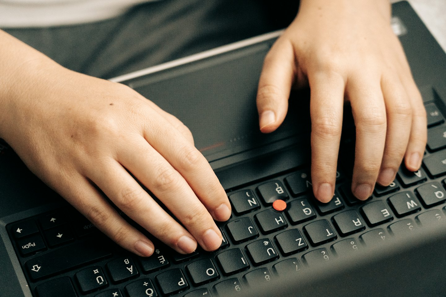 Händer som skriver på ett tyskt QWERTZ laptop-tangentbord.